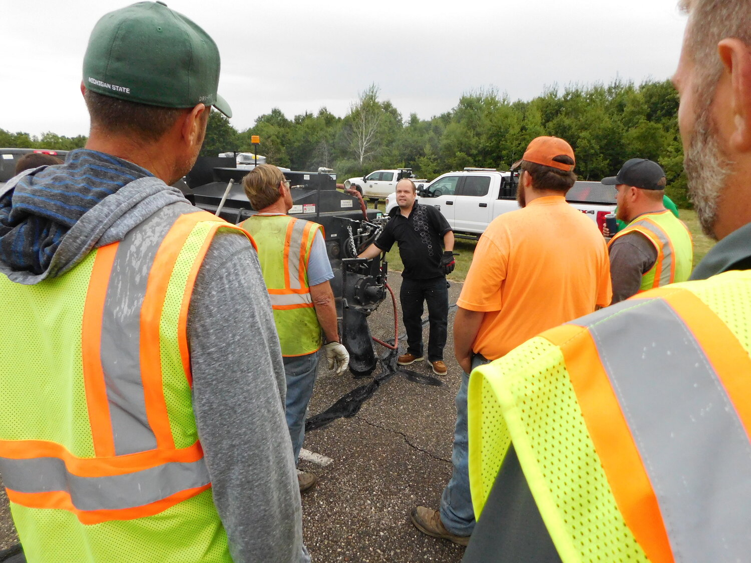 Representatives from Clare, Gladwin and Midland counties, along with the City of Clare, pay close attention to the product and machine demonstration presented Tuesday, Aug. 22 at Clare County Airport 80D.